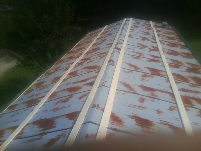 Rusted metal roof panels with new wood purlins before replacement — Storm Damage Roof Repair in South Hutchinson by Roofing Brothers