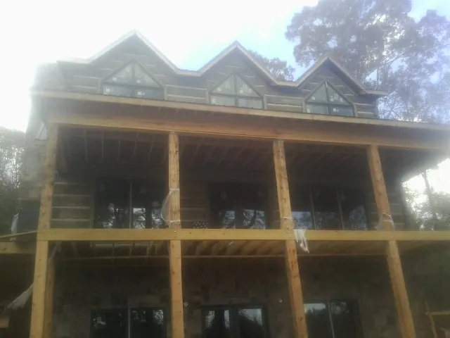 Dormers and porch framing on a large log home under construction — Roof Coating work by our crew in South Hutchinson