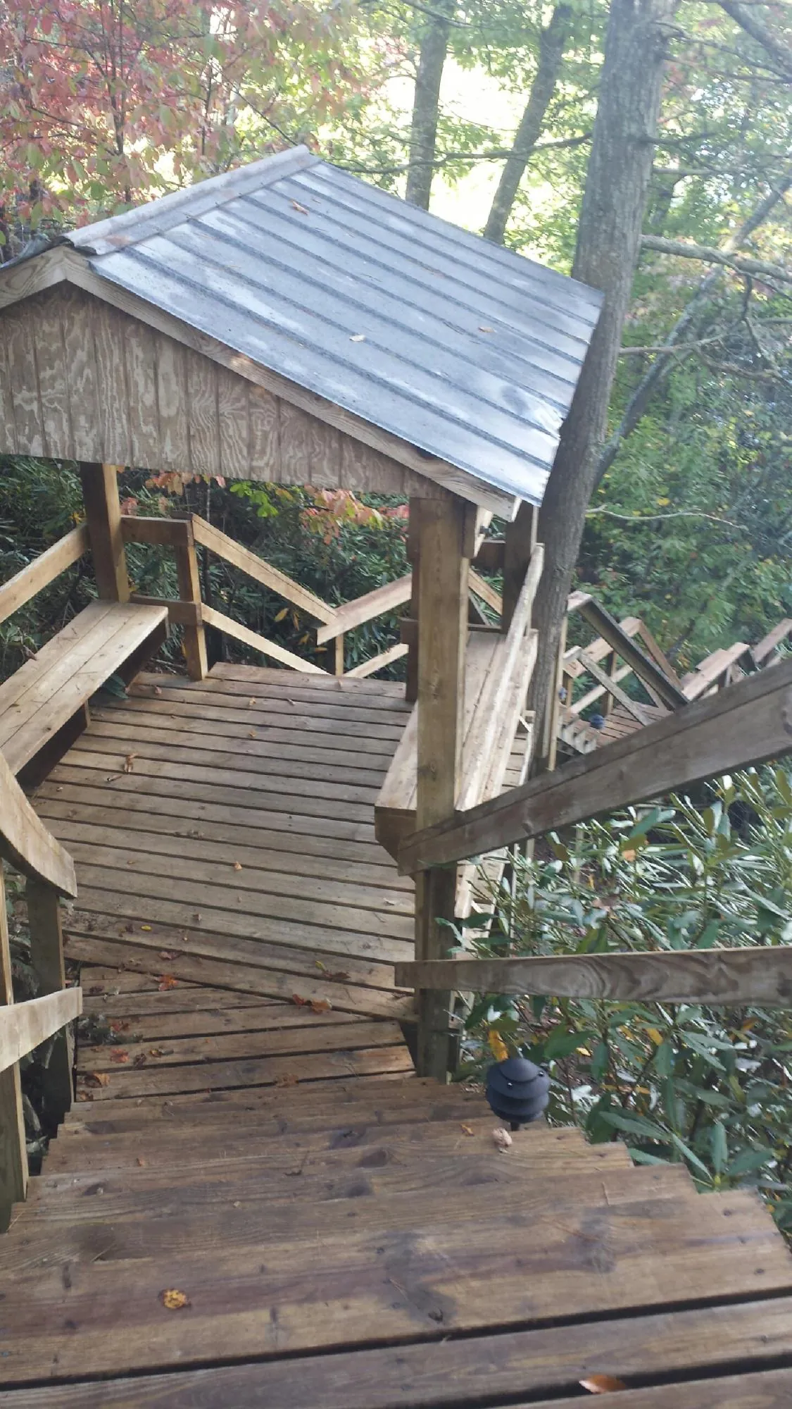 Metal roofed shelter over wooden steps on a wooded walkway — Skylight Repair & Installation work by our crew in South Hutchinson
