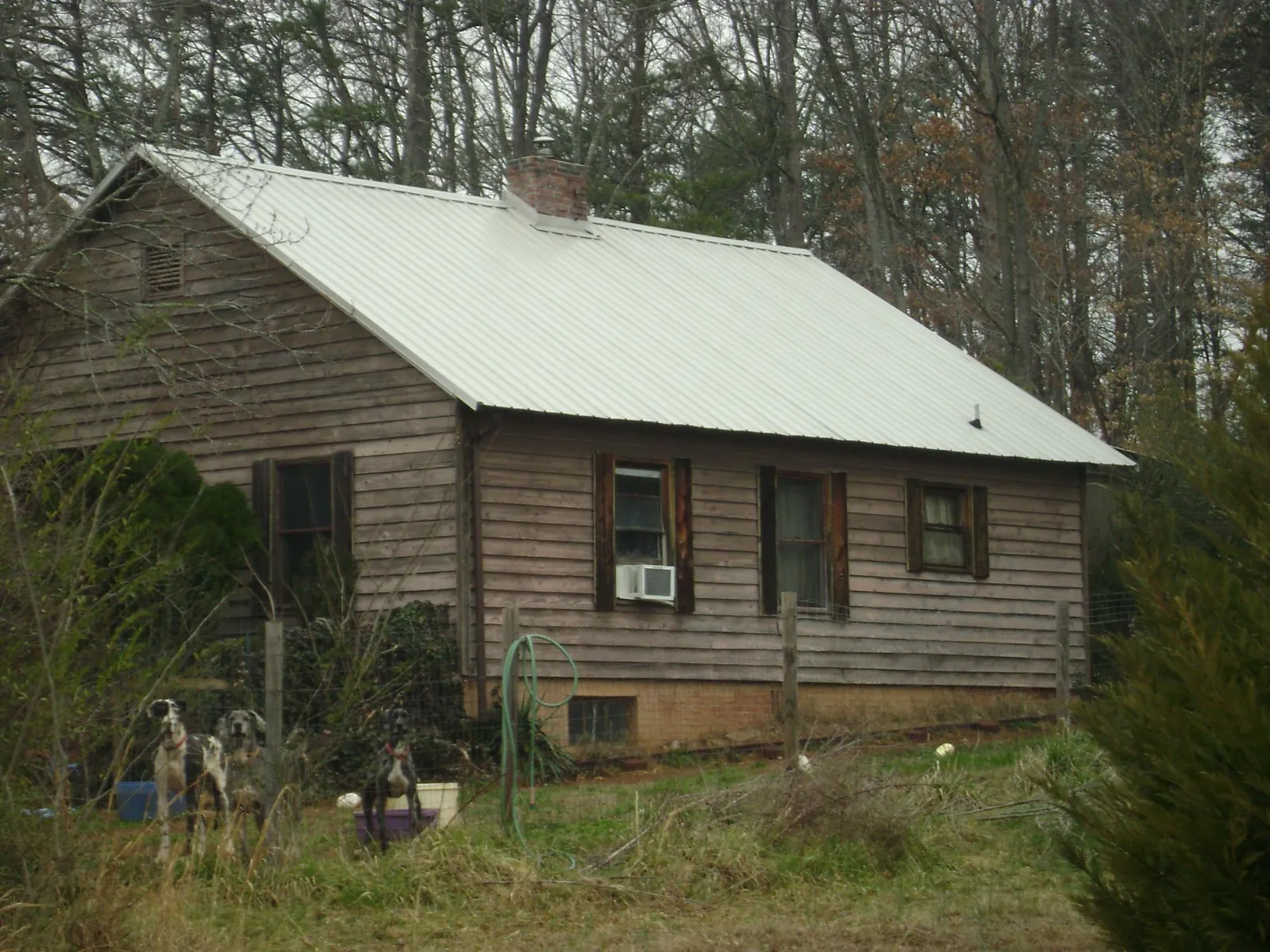 White metal roof on an old wood sided farmhouse, from a Asphalt Shingle Roof Repair job in South Hutchinson